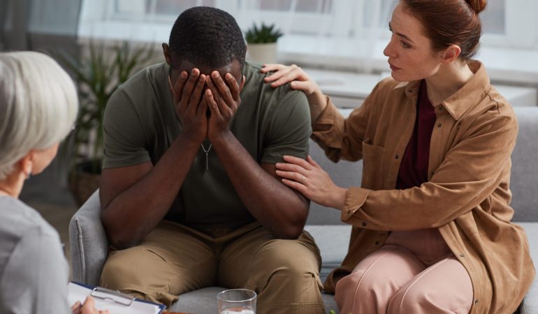 African depressed man crying while has a consultation together with his wife they visiting psychologist